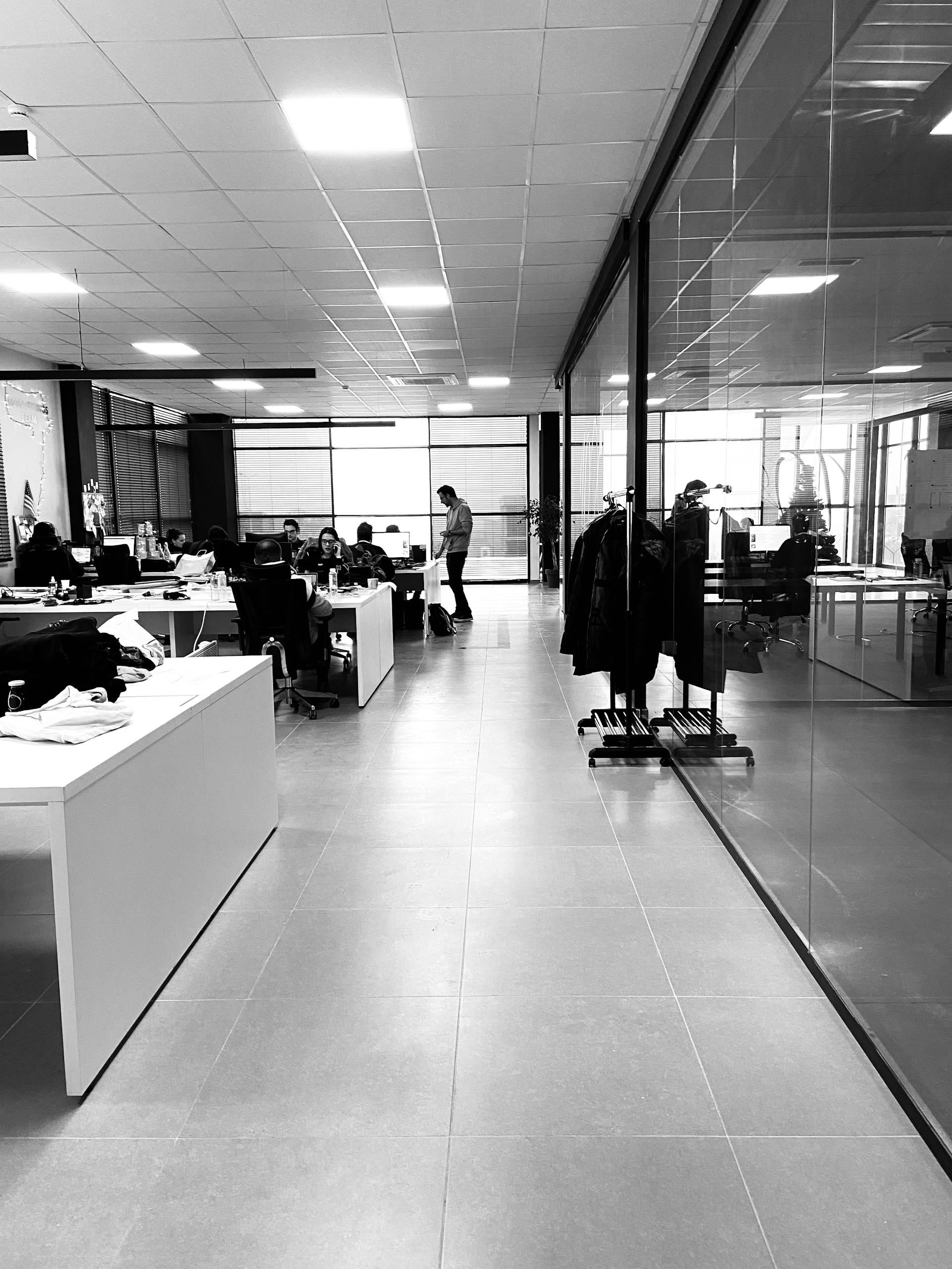 Black and white of anonymous employees working together in modern office with glass walls | Startup Operations